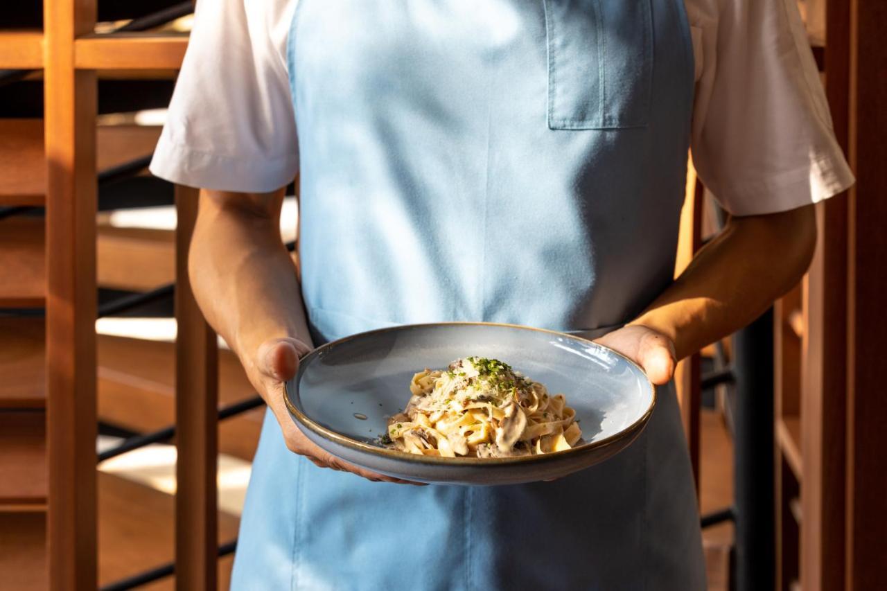 Outrigger Surin Beach Resort - Sha Extra Plus ภายนอก รูปภาพ A server holding a plate of pasta